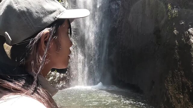 Asian woman vacation at Dolo waterfall. One of beautiful waterfall in East Java, Indonesia.