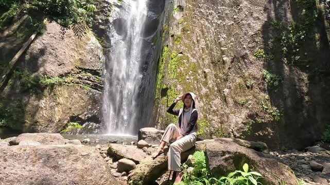 Asian woman vacation at Dolo waterfall. One of beautiful waterfall in East Java, Indonesia.
