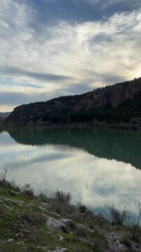 Panoramic view of the La Tranquera Reservoir with its tranquil waters surrounded by mountains and rock formations. Natural landscape with reflections in the water and an incredible sky. Zaragoza,Spain