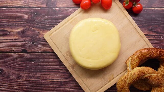 Cheese and pretzel display on wooden board with tomatoes