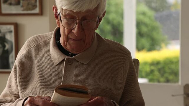 elderly man reading a book at home
