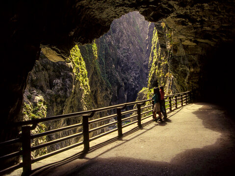 Tourists stand on the walkway inside the cave, gazing at the Taroko Gorge in Hualien, Taiwan.