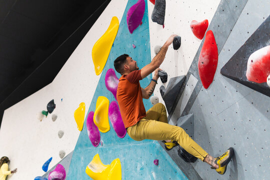 Man bouldering at indoor climbing gym