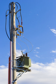 Modern electrical transformer on a pole in the Carpathian mountains. Rural digitalization and energy infrastructure against a sunrise landscape in Transylvania, Romania