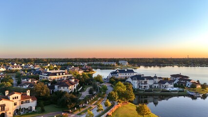Fototapeta premium Aerial view of luxury houses in Houston, Woodlands by the lake with dramatic cloudy sky in Texas, United States