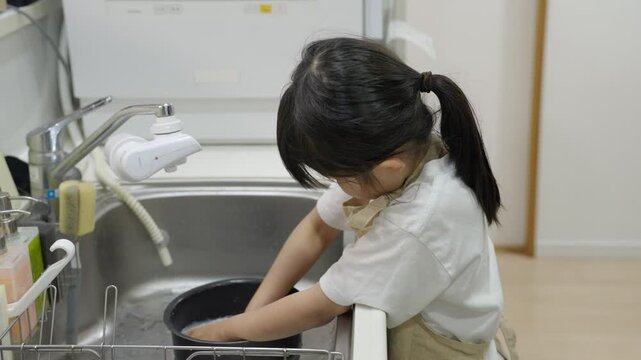 料理のお手伝いでお米を研ぐ子供