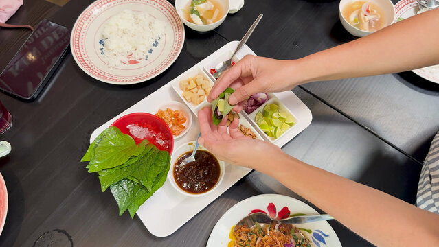 Hands Assembling Traditional Thai Miang Kham Savory Leaf Wraps