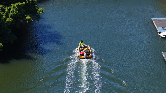 Workers in High-Visibility Gear Pilot a Small Utility Boat on a Canal