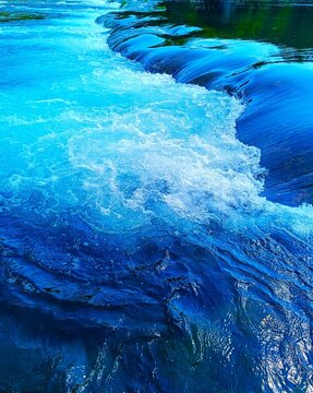 River with clean water and waterfalls in magnificent green nature with trees and blue sky