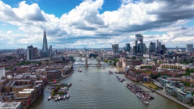 Aerial view of the cityscape of London, England, with City, Tower Bridge and River Thames during a sunny summer day with cloudscape