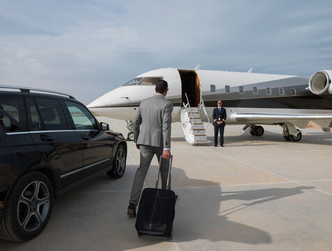 Middle Eastern business team boarding private jet for executive travel at desert airport