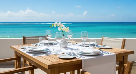 Obraz premium An elegant wooden dining table with white linens sits on a sunny terrace overlooking the calm turquoise ocean waves under a bright blue sky, peaceful, scenery, exterior