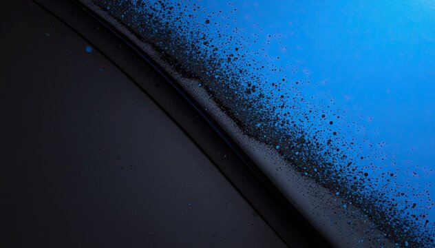 A dramatic abstract close-up showing a diagonal transition from a dark shadowy plane to a vibrant blue textured surface covered in fine particles