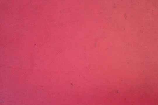 Cracked paper reveals bold red streak against dark background. Texture suggests torn, aged, or distressed material. Sharp contrast draws eye to jagged, vivid line. Abstract design evokes movement