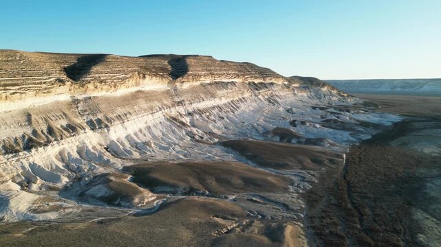 Drone flight over a scenic desert valley with rocky white and brown cliffs in the Kochak Bay nature reserve. Unique geological relief of Mangystau, wild nature, Martian landscapes of Kazakhstan, weath