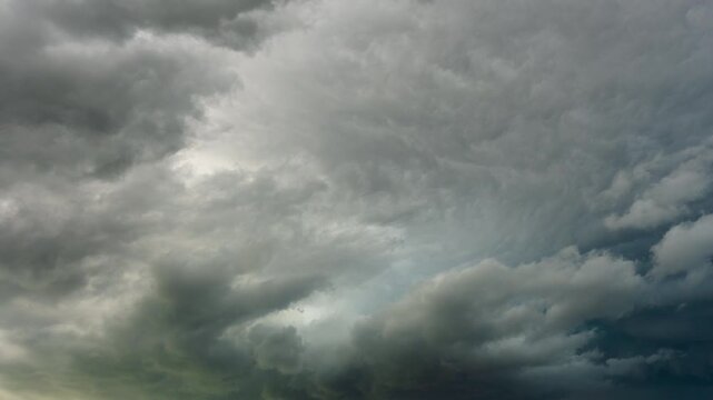 Dark rain clouds gathering and shifting in an intense weather sky scene