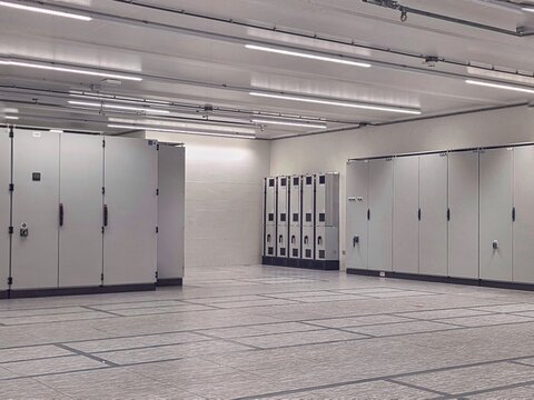 Large industrial electrical control room with switchboards and technical infrastructure inside modern facility.