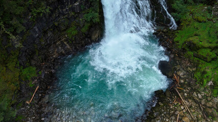 Majestic waterfall cascades into a tranquil turquoise pool amidst lush green forest in the heart of nature's beauty © Tetiana