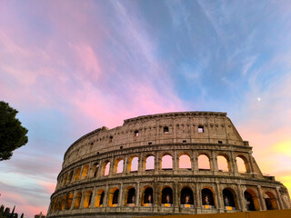 Fototapeta premium Stunning sunset illuminates the ancient architecture of the Colosseum in Rome