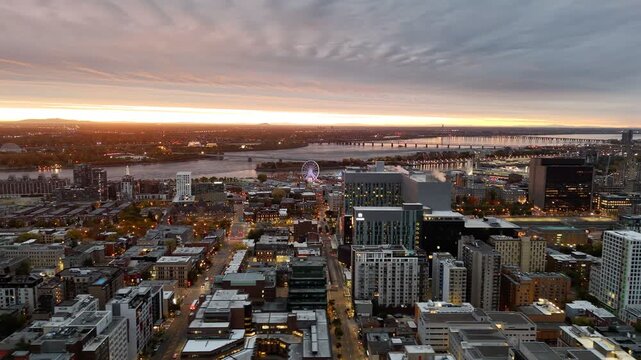 Vibrant sunrise over Montreal skyline with St Lawrence River and La Grande Roue reflecting colorful evening sky. g.
