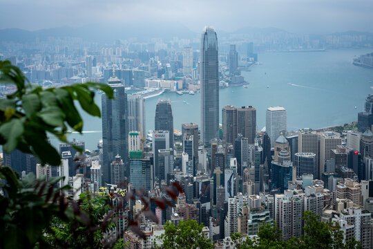 Panoramic view of Hong Kong's dense urban skyline and Victoria Harbour on a hazy day