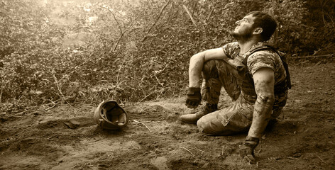 Fototapeta premium Young soldier sitting on the ground