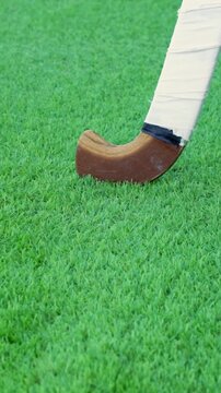 Hockey player, stick and ball on artificial turf.