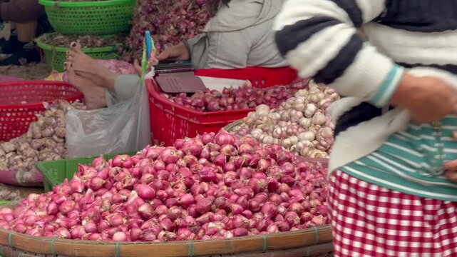 Close-up view of fresh shallots and garlic sold at traditional market in Vietnam Authentic local street market scene showcasing colorful vegetables, daily life and Asian food culture in Southeast Asia