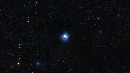 Obraz premium Observe a brilliant blue reflection nebula luminous against the dark cosmic expanse. Numerous white and orange stars twinkle across the deep black sky.