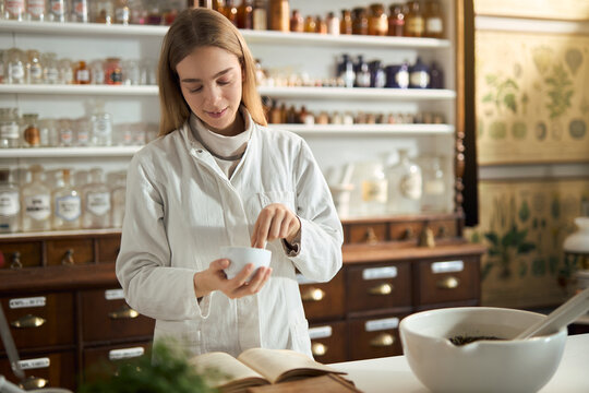 Young female chemist  making homeopathic medicine in a laboratory.