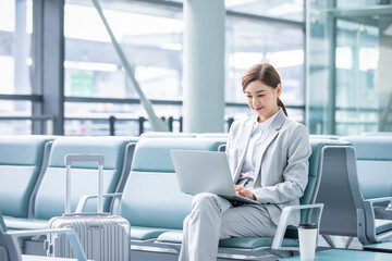 Fototapeta premium Businesswoman Working on Laptop in Airport Lounge