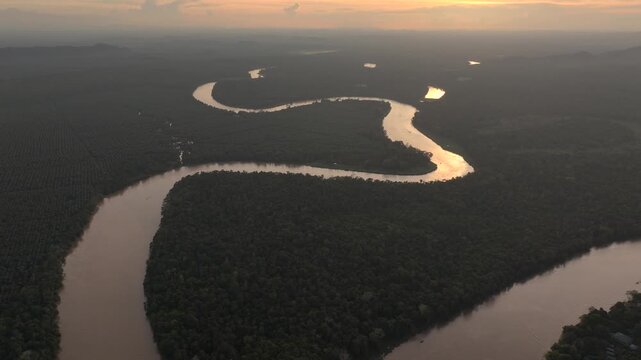 Aerial Shot of a Large Brown River, winding through a Tropical Rainforest. Kinabatangan River, Sabah, Borneo, Malaysia.