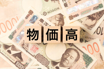 Fototapeta premium 「物価高」と書かれたブロックとたくさんの一万円札