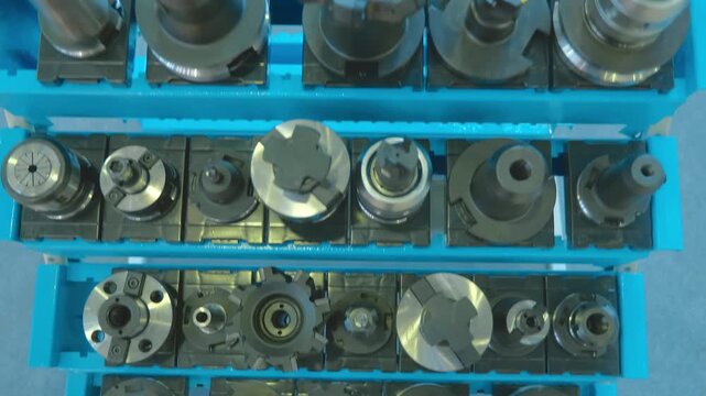 A range of new, shiny cutters for milling machines, of various shapes and purposes, located in its own collet chuck, are presented at the exhibition. Closeup. Shot in motion 