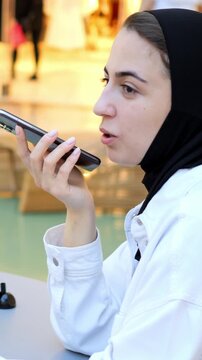 Woman In Hijab Recording Podcast Snippet Into Smartphone, Confident Delivery And Clear Enunciation, Ambient