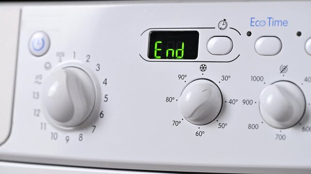 Close-up of the control panel of a modern washing machine white color.  Digital display with the inscription end washing.