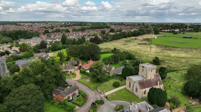 Aerial Drone View of Historic Stone Church Tower and Rooftops in Barton Seagrave Northamptonshire
