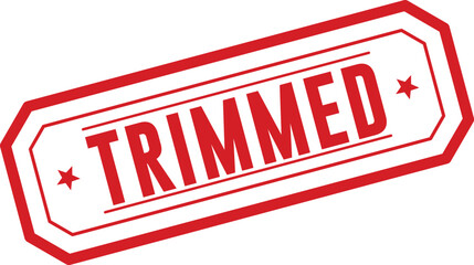 This striking red rubber stamp prominently featuring the word TRIMMED on a pristine white surface indicates refinement or reduction © designboundary