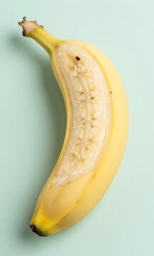 lengthwise halved banana lies soft pastel mint background illuminated gentle overhead natural light emphasizing