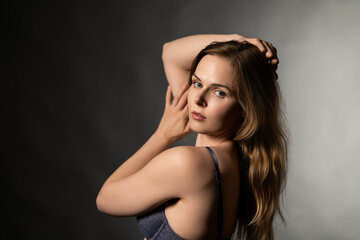 Fototapeta premium Woman posing in blue lace lingerie, looking at camera with sensual expression