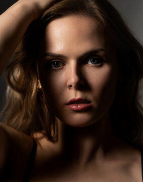Woman's portrait with strong light and shadow playing across her eyes and features