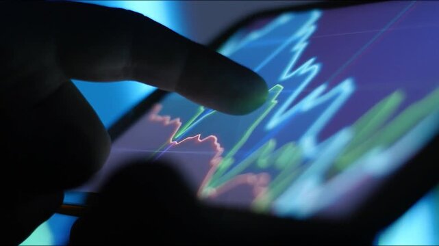 trader investor using smartphone real time stock market monitoring with candlestick candle chart in modern tablet laptop computer. trade app crypto graphs on mobile phone. analysis Finance Business