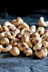 Fototapeta premium A stack of cashews resting on a flat surface, ideal for snacking or serving at a party. vertical frame