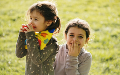 Fototapeta premium Portrait of two girls having fun in the park wearing clown costumes.