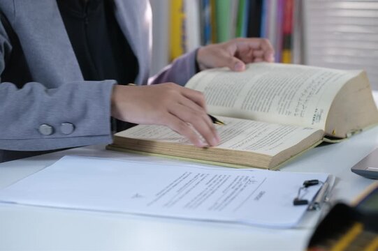 Opening a book to search for specific information, educational learning in literary textbooks in academic fields at the reading table in the school library classroom. Cognitive knowledge and learning.