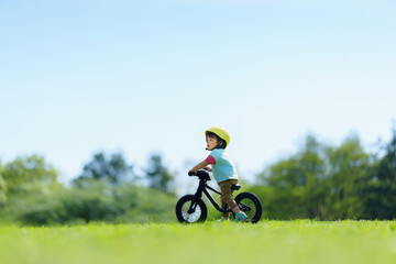 Obraz premium キックバイクで公園を走る2歳の男の子