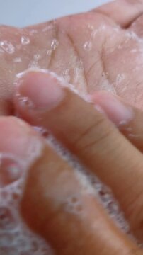 Showing soap foam bubbles on hand and rubbing palm gently. Close up view, hand hygiene concept, cleansing texture for daily skincare routine.