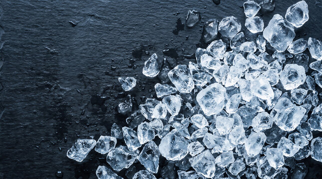 Crushed ice cubes on a dark grey slate background