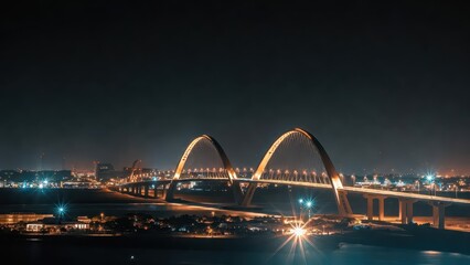 Naklejka premium Illuminated Arched Bridge Spanning Waterway at Night with City Lights and Starbursts