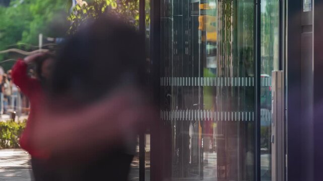 Time-lapse side view busy shopping mall entrance people crowd enter and exit store through revolving door. Rush hour crowded shopping center, glass door rotating fast motion
